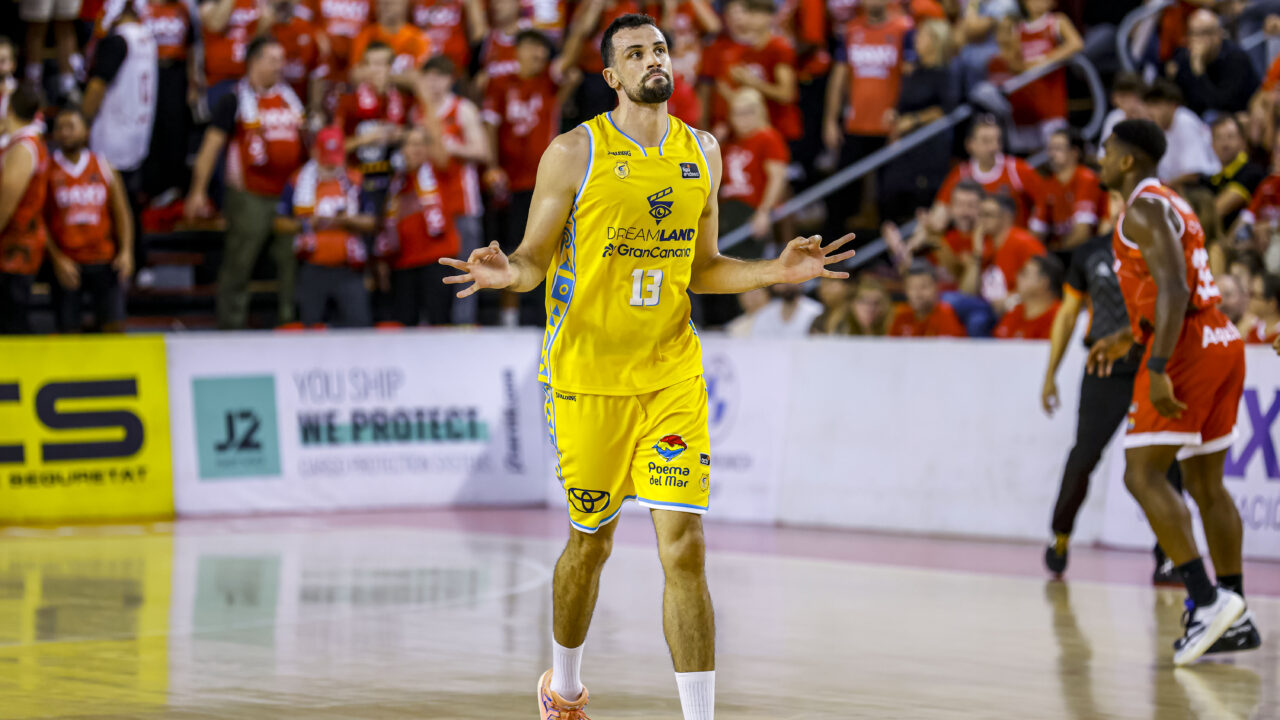Jugador del Gran Canaria celebra en la cancha, con público animando de fondo.