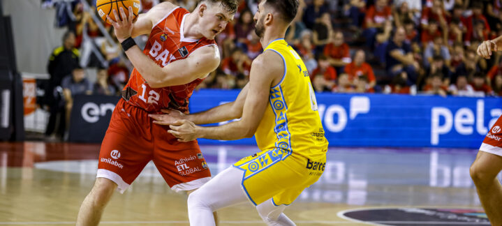 Jugadores de baloncesto compiten por el balón en un partido emocionante.