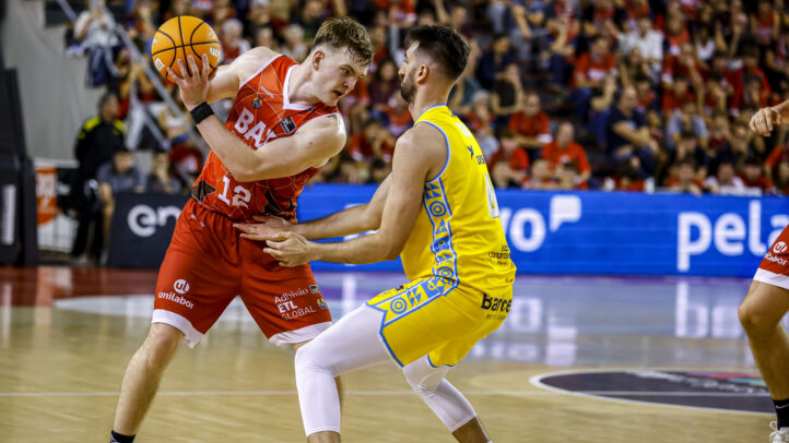 Jugadores de baloncesto compiten por el balón en un partido emocionante.