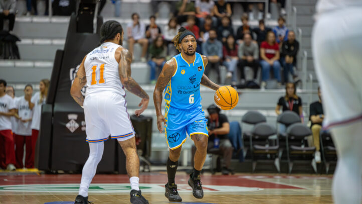 Jugador del Dreamland Gran Canaria driblando el balón en un partido de baloncesto.