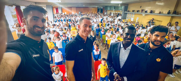juntos en una mañana de sonrisas y cariño",Jugadores del Club Baloncesto Gran Canaria posan con niños en un evento escolar.