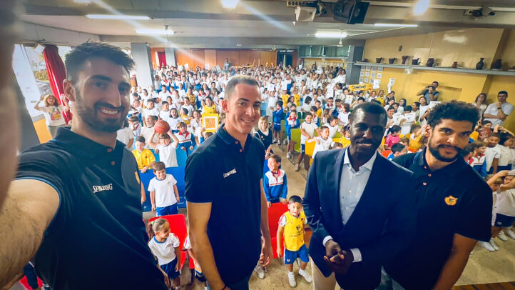 juntos en una mañana de sonrisas y cariño",Jugadores del Club Baloncesto Gran Canaria posan con niños en un evento escolar.