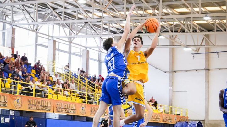 Jugador del Gran Canaria U22 salta para hacer una canasta mientras es defendido.