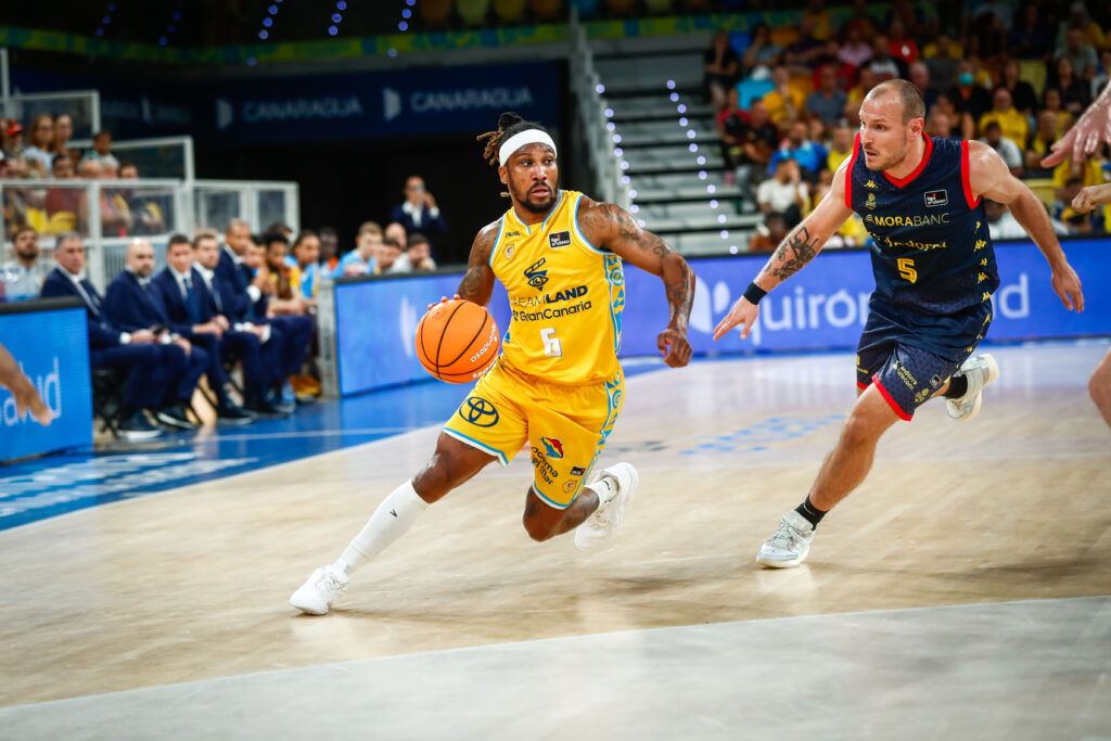 Andrew Albicy botando el balón dirigiéndose hacia la canasta.