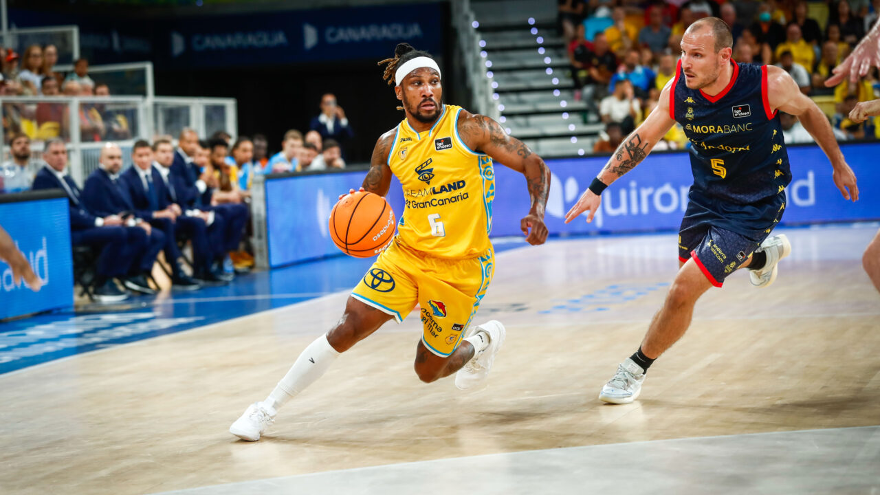 Andrew Albicy botando el balón dirigiéndose hacia la canasta.