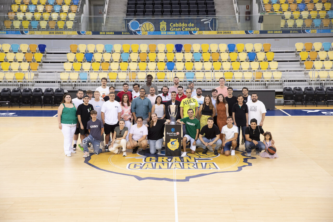 Grupo de voluntarios posando en la cancha del Club Baloncesto Gran Canaria con un trofeo.